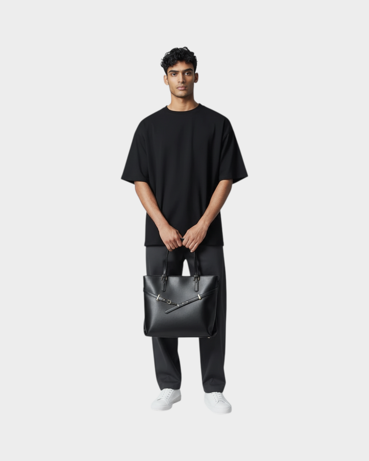 SIEVRA Span black vegan leather tote bag held by a man wearing a black t-shirt and grey trousers