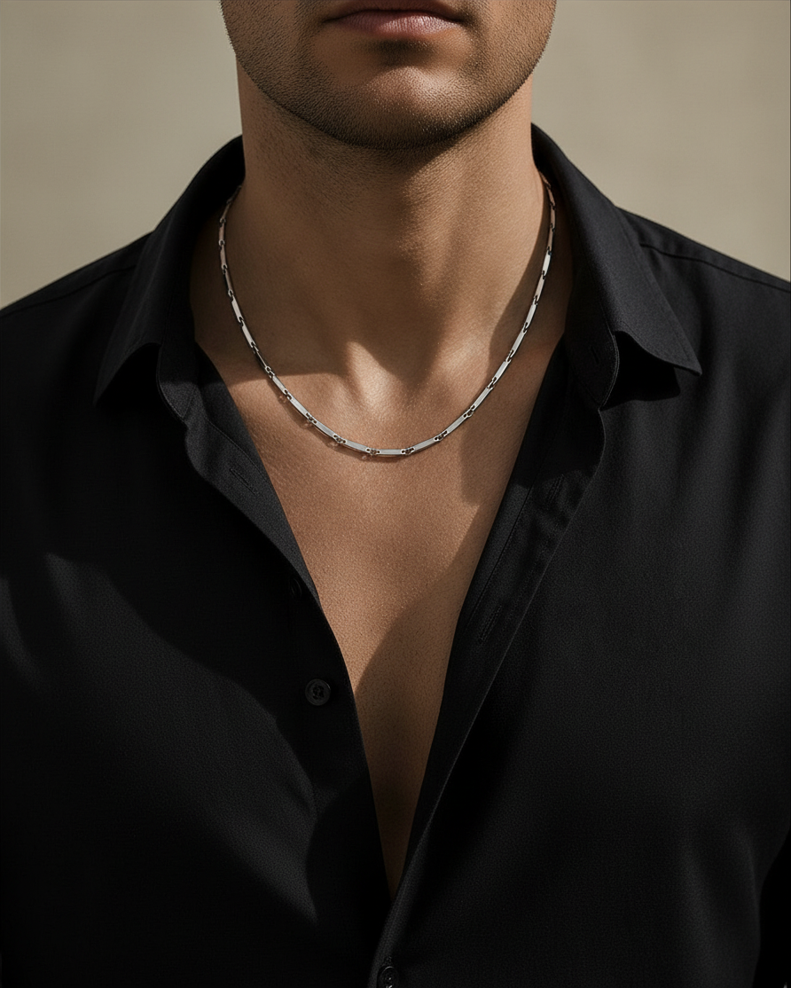 SIEVRA Facet Necklace featuring diamond-cut geometric stainless steel links worn on a man in a black shirt