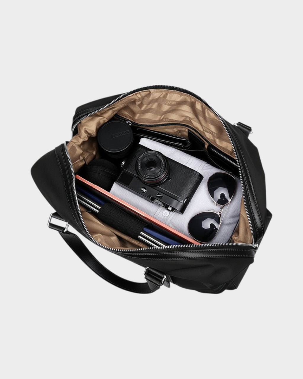 SIEVRA black water-resistant nylon foldable duffle bag filled with camera, sunglasses, and travel essentials.