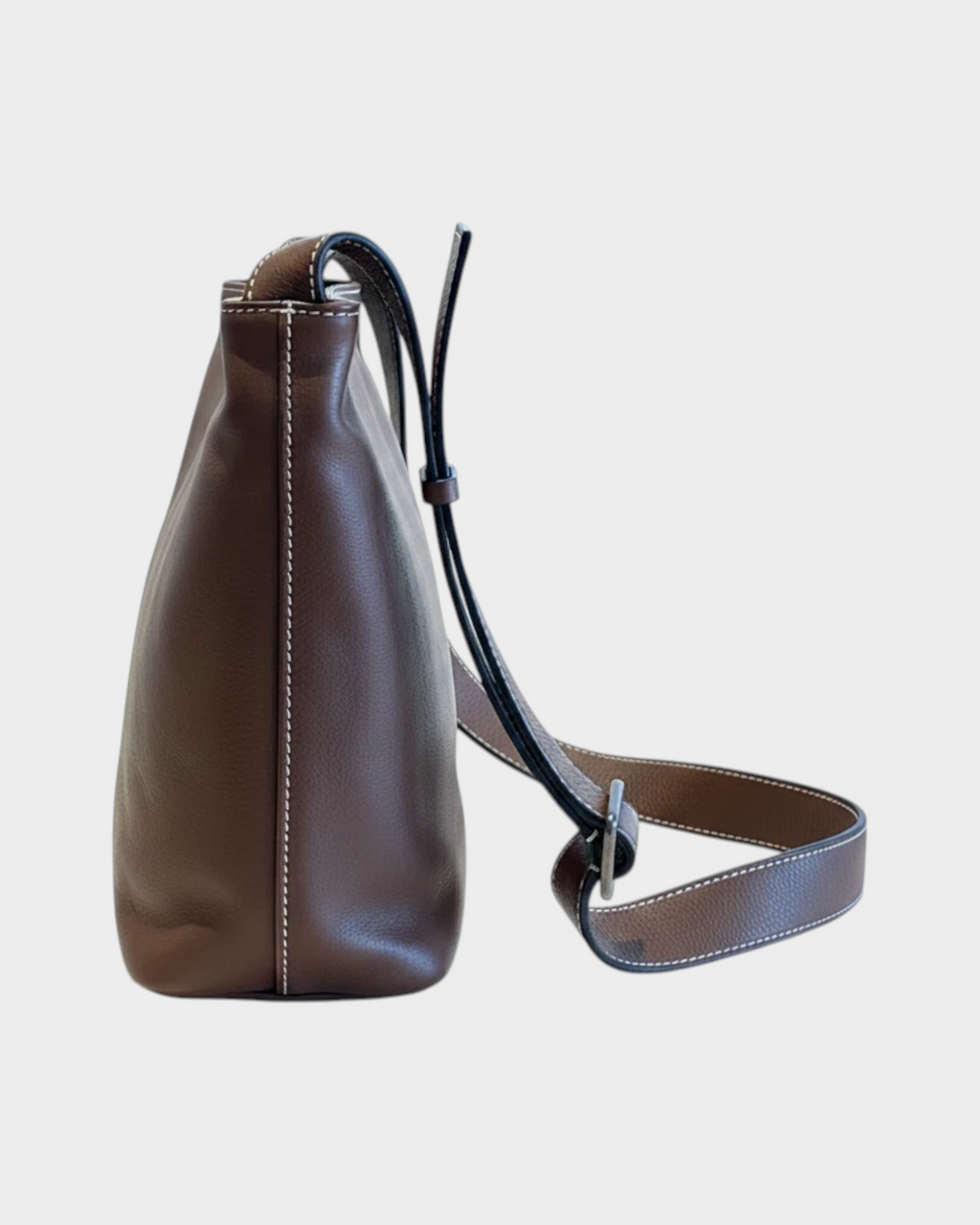 SIEVRA Basin coffee brown full-grain cowhide leather bucket crossbody bag, side view with adjustable strap.