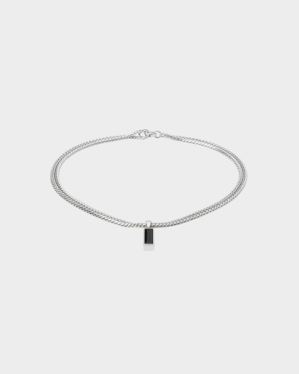 SIEVRA Baton pendant necklace featuring a vertical black crystal bar on a silver stainless steel curb chain.