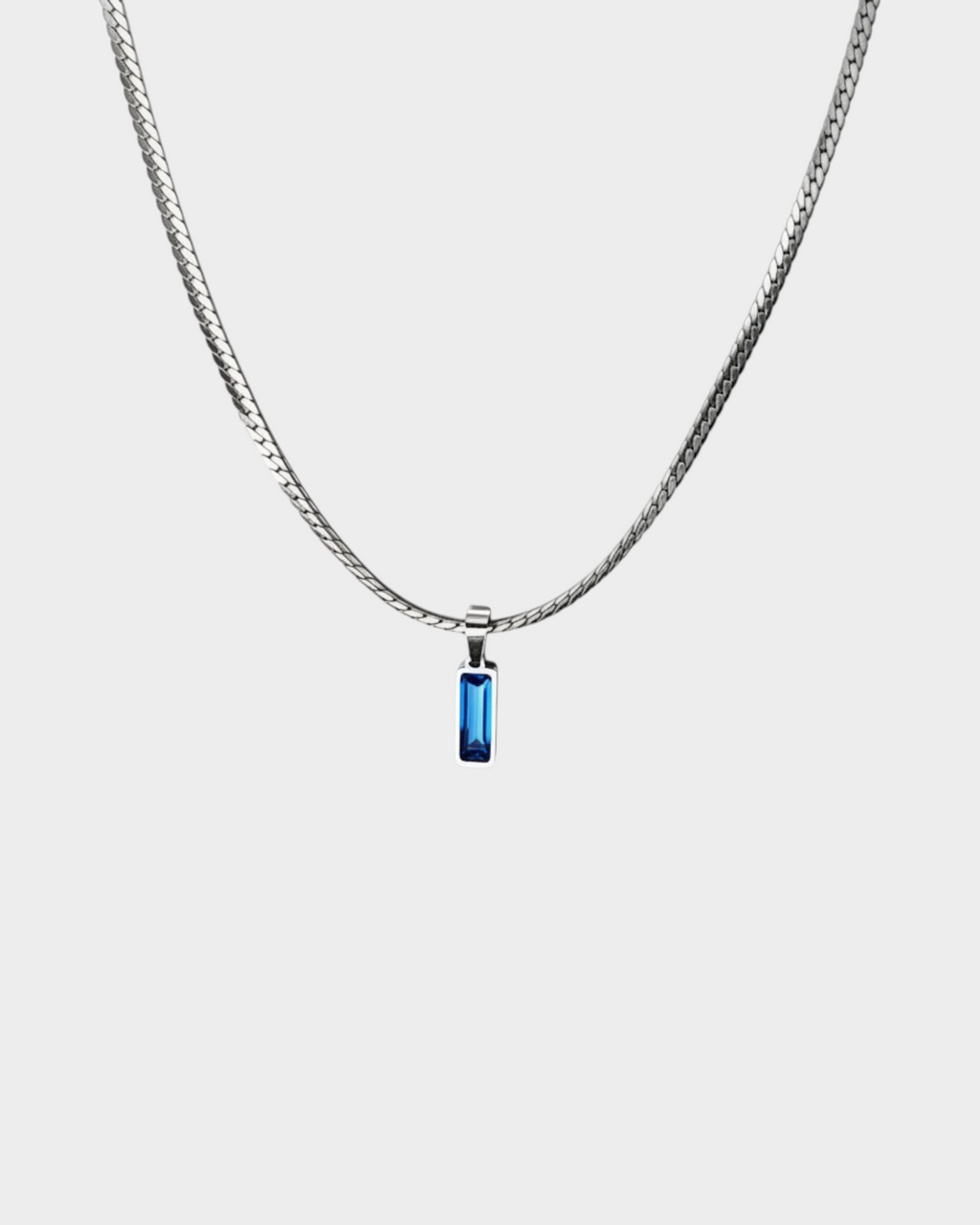 SIEVRA Baton pendant necklace featuring a vertical stainless steel bar with a blue crystal inlay on a curb chain