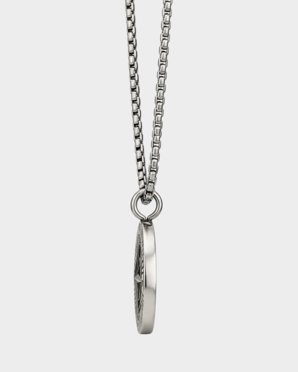 SIEVRA Bearing pendant necklace featuring a stainless steel compass medallion on a curb chain, side view.