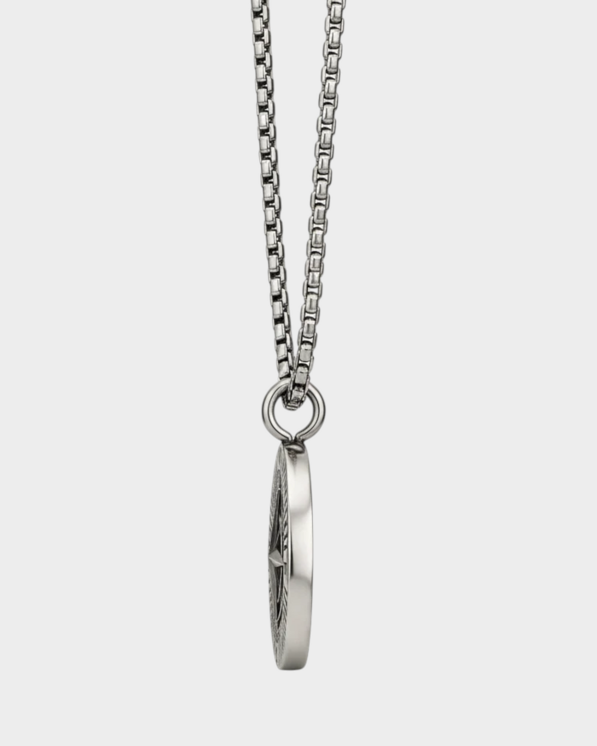 SIEVRA Bearing pendant necklace featuring a stainless steel compass medallion on a curb chain, side view.