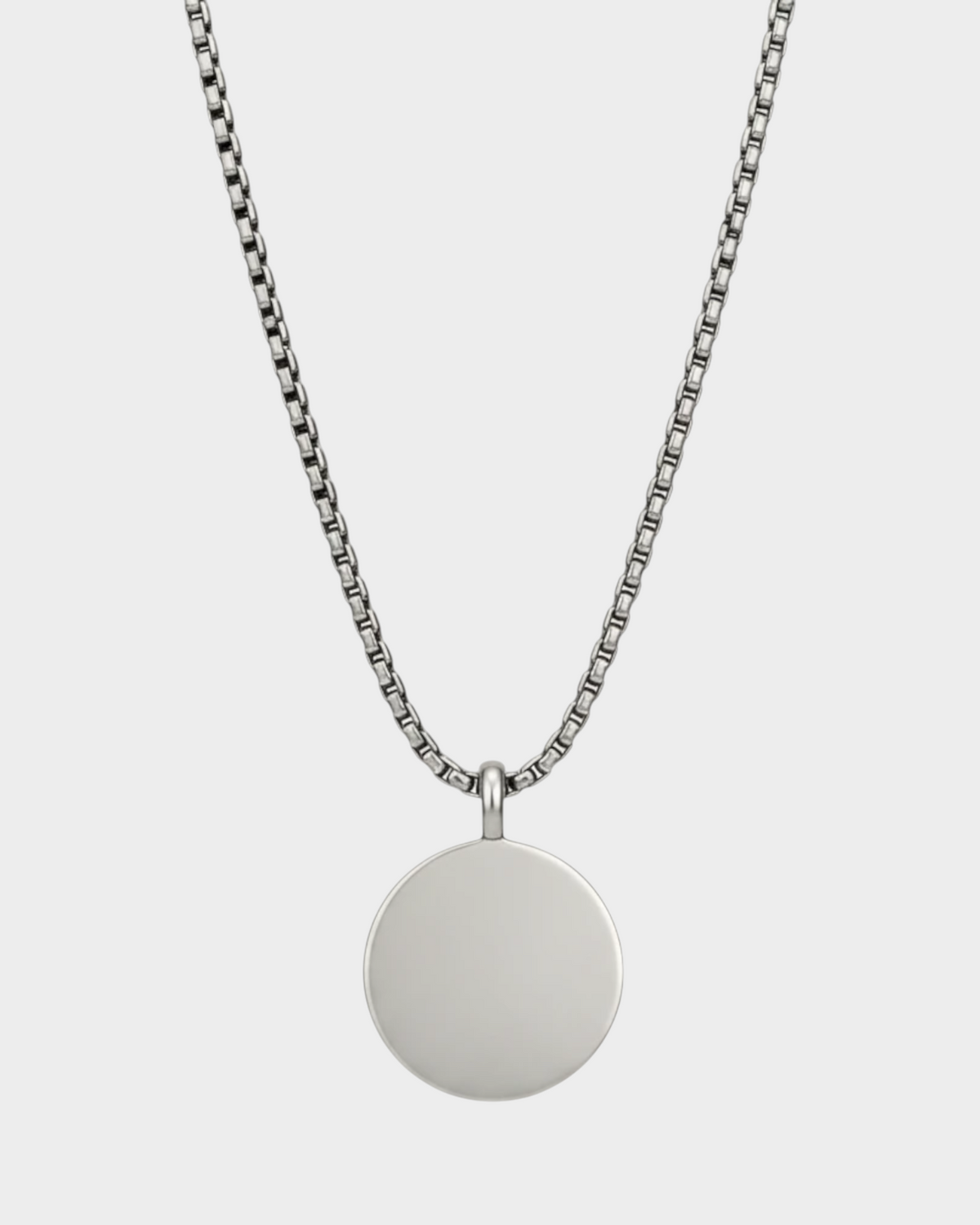 SIEVRA Bearing pendant necklace featuring a round compass-face medallion on a silver stainless steel curb chain.