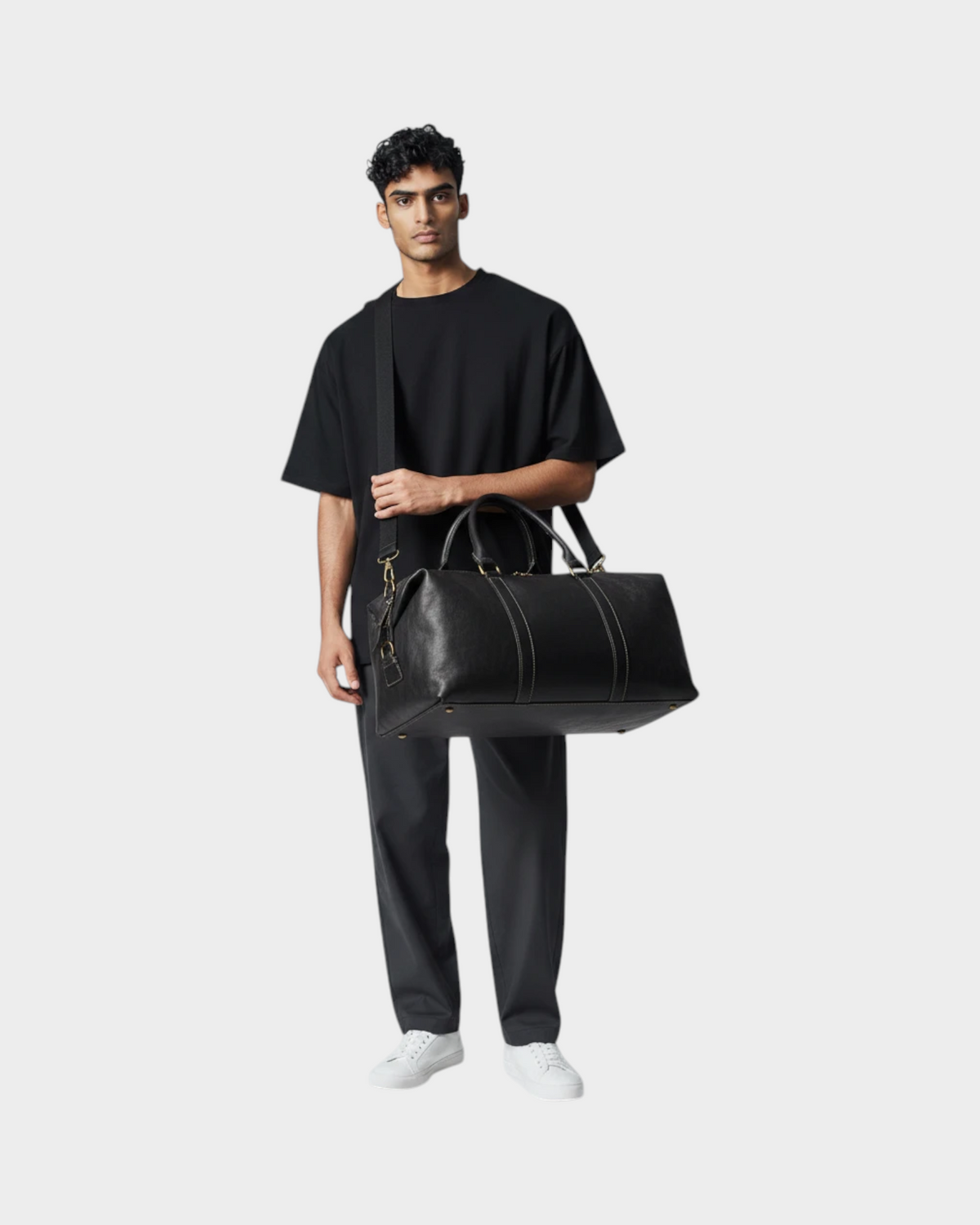 SIEVRA Transit Weekender Bag in black first-layer cowhide leather held by a man in a studio setting