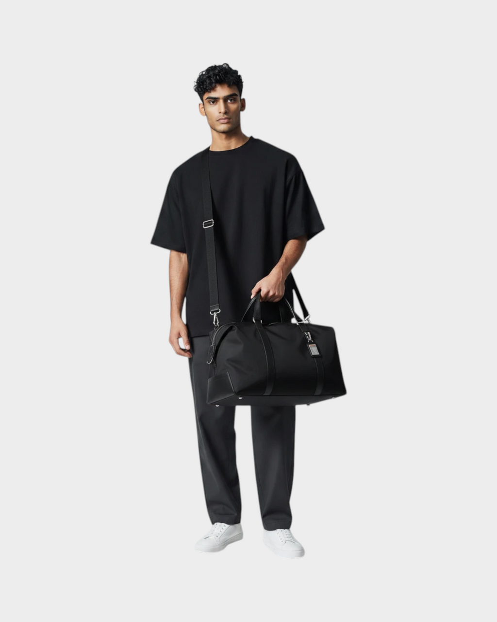SIEVRA black water-resistant nylon foldable duffle bag with leather trim held by a man in a black t-shirt