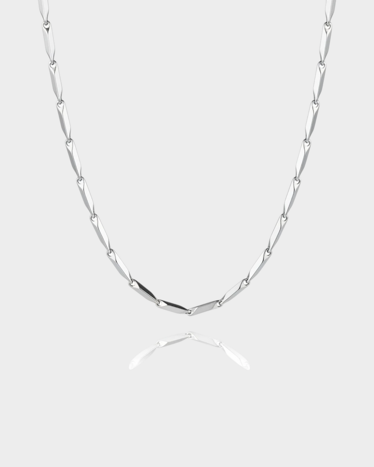 SIEVRA Facet Necklace featuring diamond-cut geometric stainless steel links that reflect light