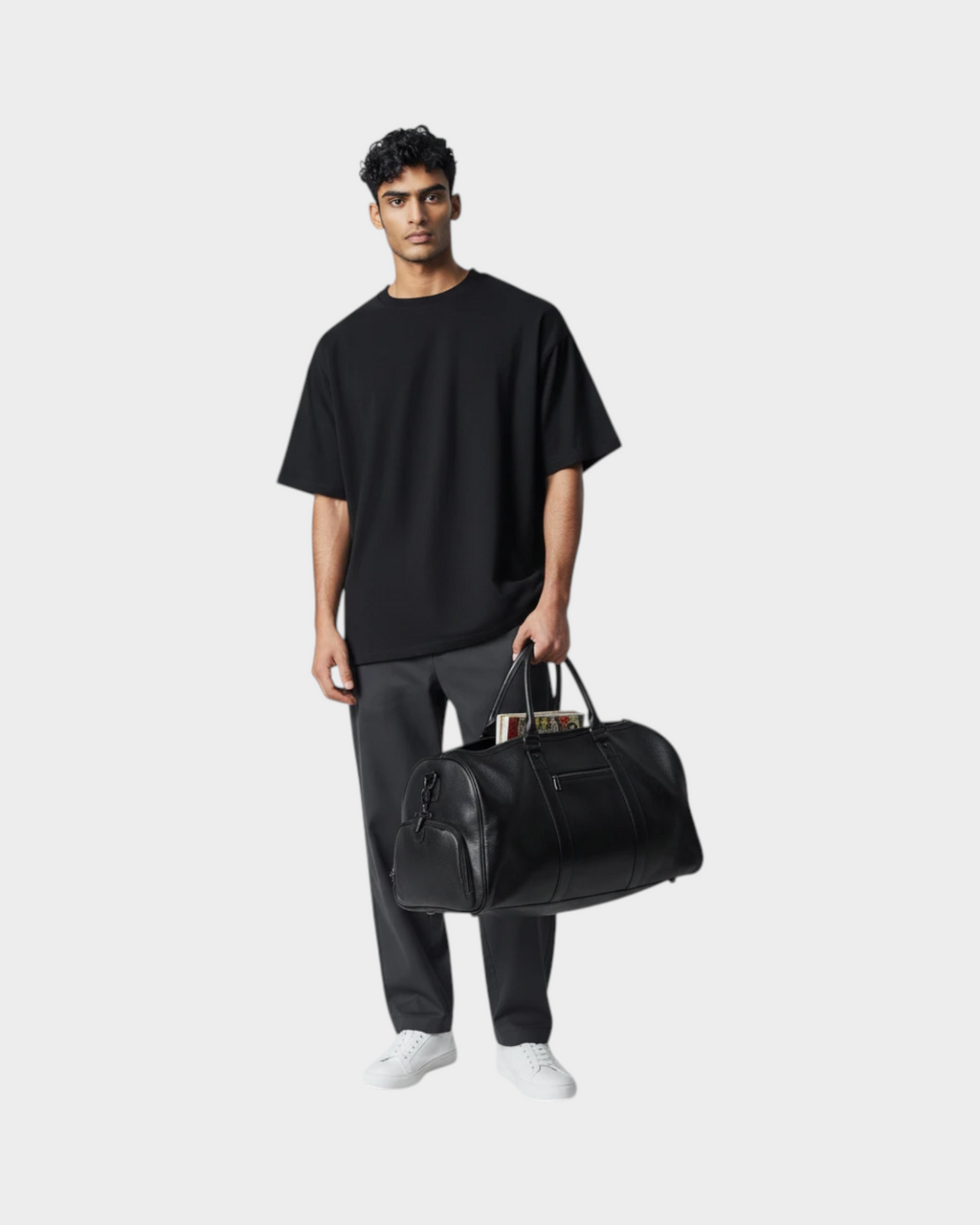 SIEVRA Haul travel bag in black first-layer cowhide leather held by a man in a black t-shirt and grey trousers