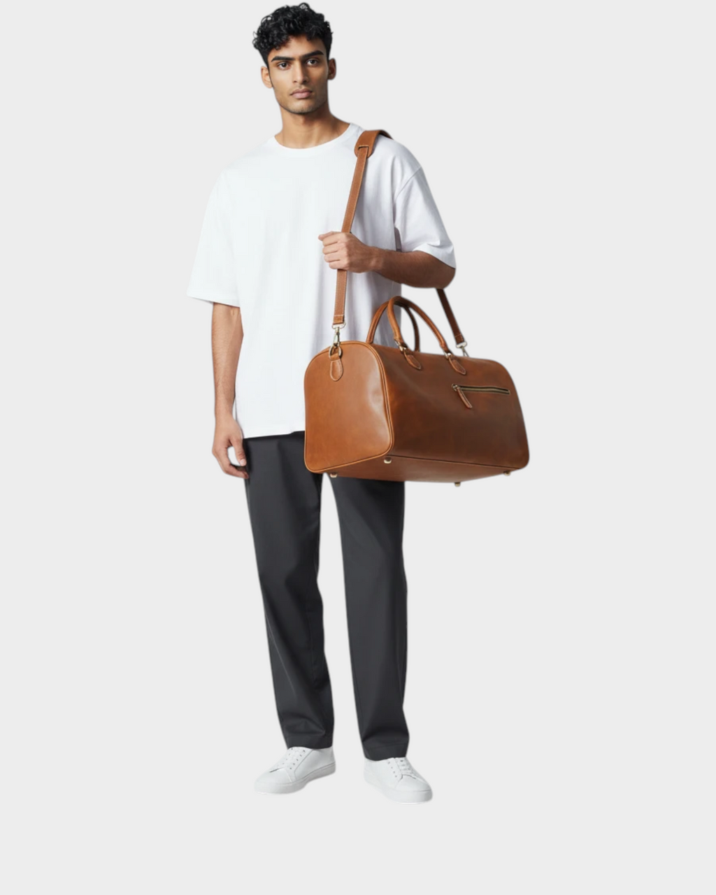 SIEVRA Voyage travel bag in light brown Crazy Horse leather with antique brass hardware carried by a man