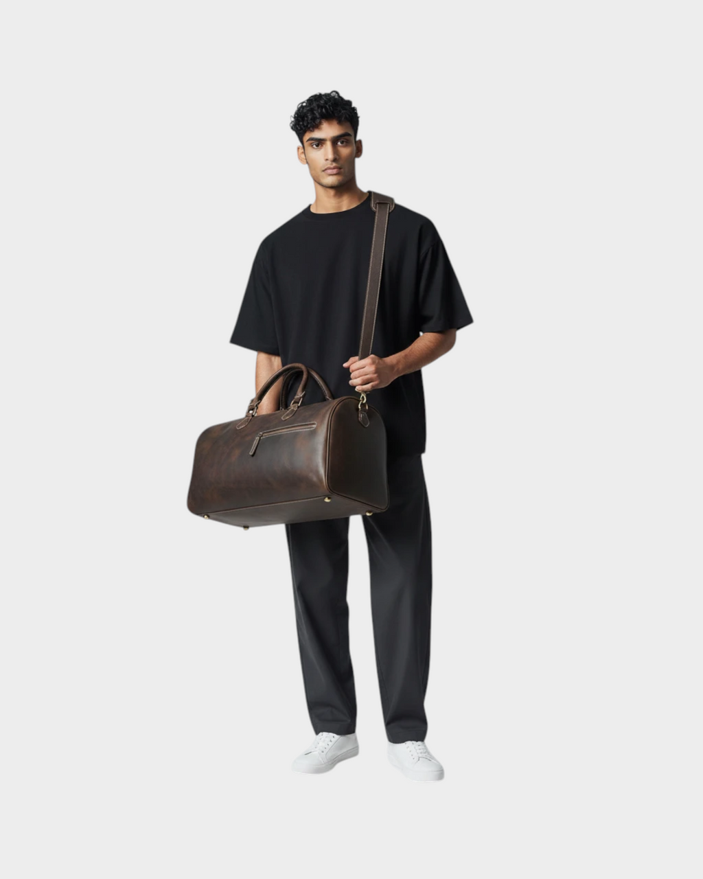 SIEVRA Voyage travel bag in dark brown Crazy Horse leather with antique brass hardware carried by a man